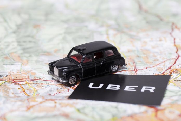 Uber logo with a black London style taxi -Ink Drop shutterstock